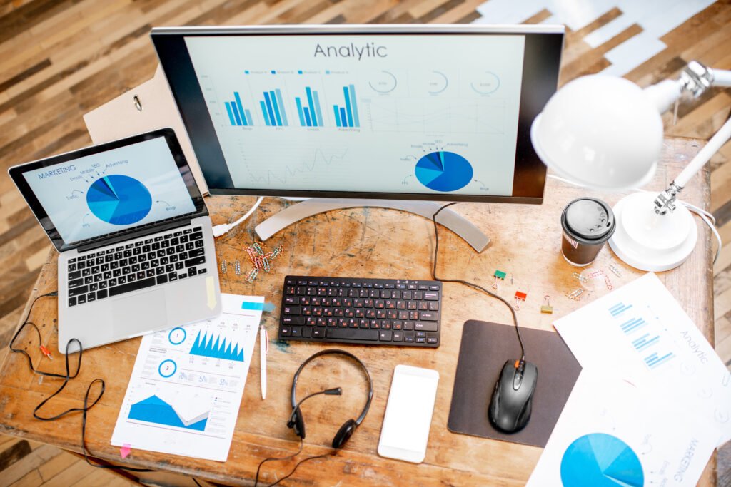 View from above on the working place with different analytics or statistics charts, screenshots and paper drawings